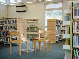 lirary with small beige chairs with bookcases