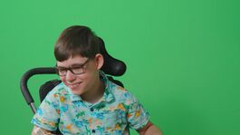 Child in wheelchair in front of green screen