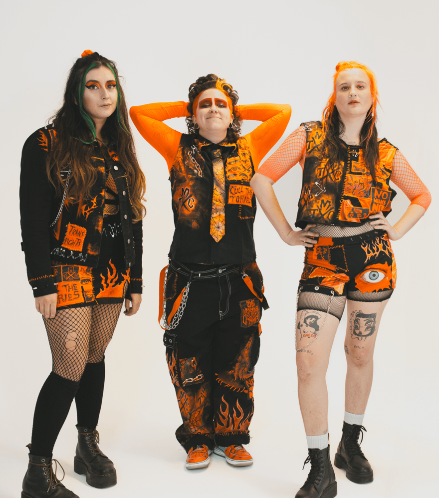 The Menstrual Cramps wearing black and orange standing in front of a white background