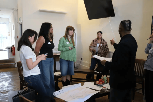 A group of young people listening to a man in a group discussion 