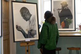 Woman looking at two photographs exhibited as part of 