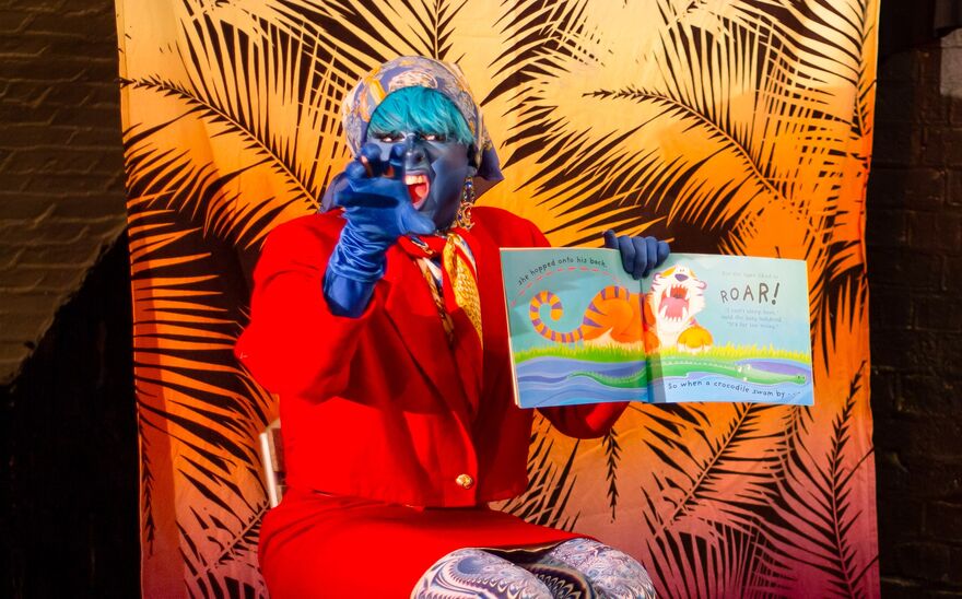A Drag queen roars while reading a story book