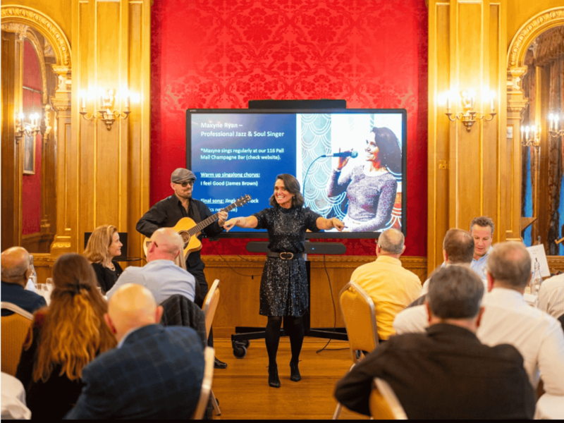 Singer with guitarist and delegates of an event singing