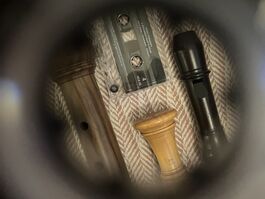Three recorders and a cassette tape seen through the hole in a tape.