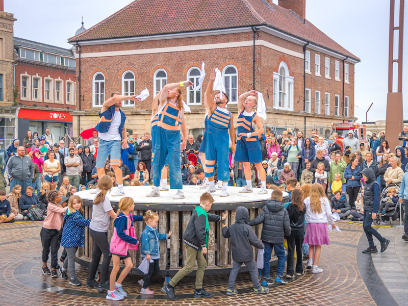 Performers alongside community cast and the giant wheel