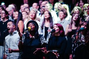 A range of singers with two people on mics