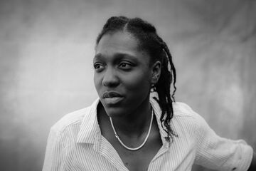 A Black And White Image Of A Black Woman With Braids Looking Wistfully Into The Distance