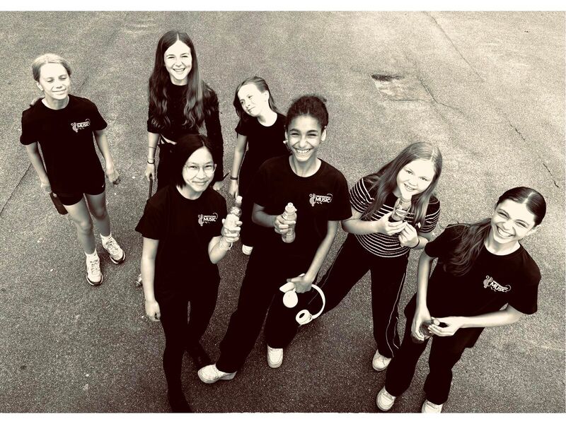 A Black And White Image Of Young Female Musicians Smiling With Instruments