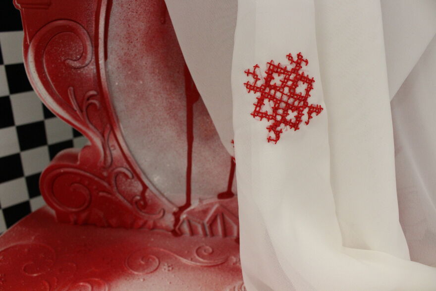 Three embroidery pieces with geometric patters on top of white fabric