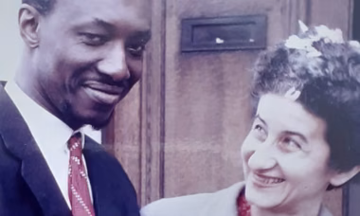 Hanna and Patrick pictured smiling at one another outside a door