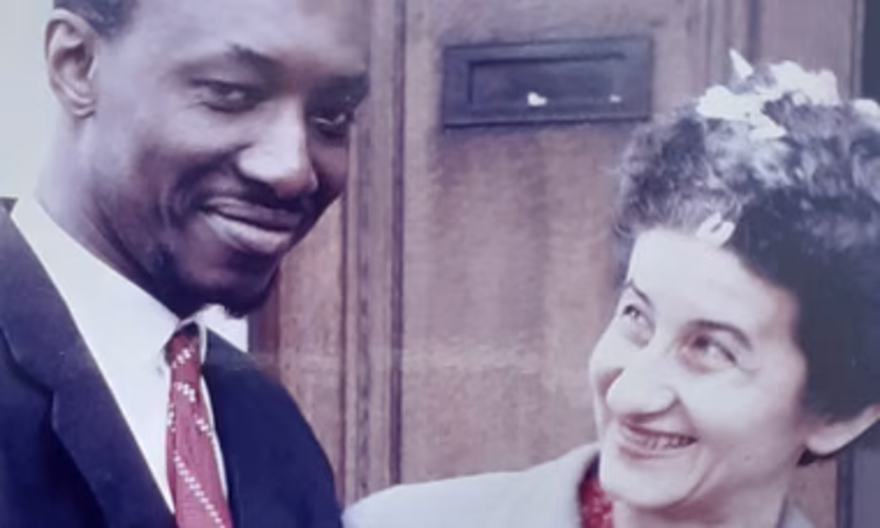 Hanna and Patrick pictured smiling at one another outside a door