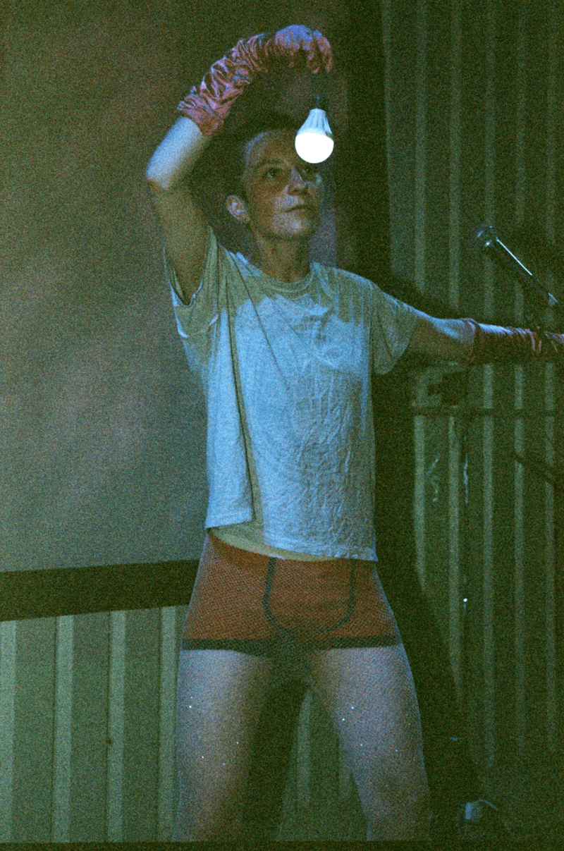 Artist performing with lightbulb in front of their face