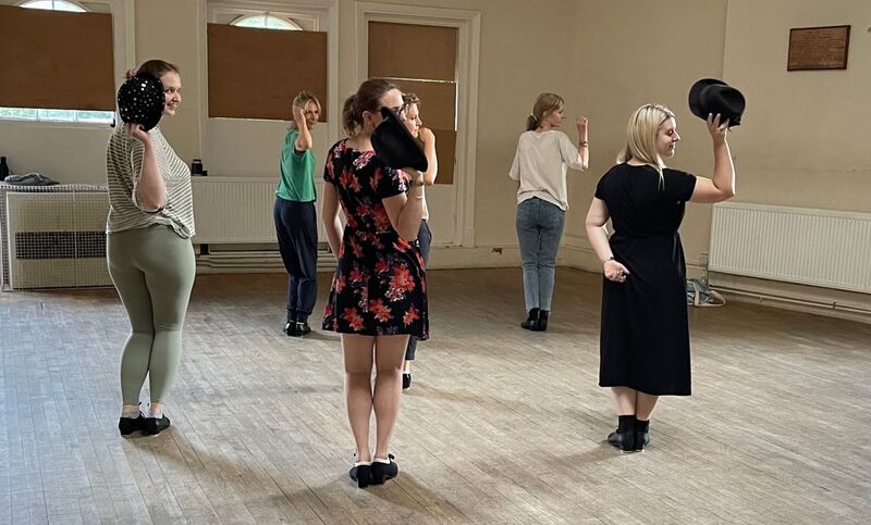 A few adults practising with their bowler hats