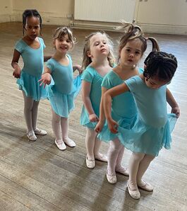  A line of three year olds waiting to about to dance around the room